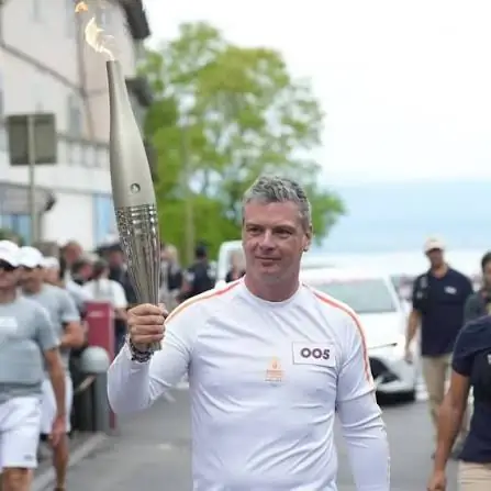 Alain Simac portant la flamme olympique